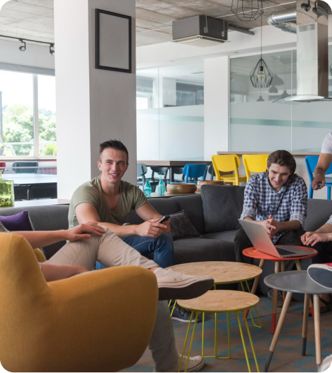 Team members relaxing and talking in a bright office lounge